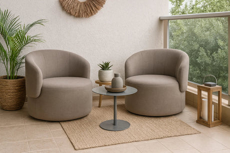 Dos poltronas redondas tapizadas en tono arena ubicadas en una terraza decorada con plantas, mesa auxiliar metálica, alfombra de fibra natural y farol de madera