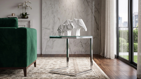 Esculturas geométricas de elefantes blancos sobre una mesa auxiliar de cristal y metal en un living elegante.