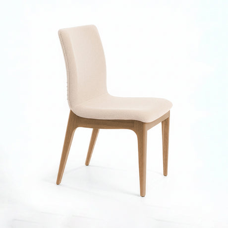Silla acolchada con patas de madera en color vainilla.