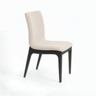 Silla acolchada con patas de madera en color beige claro.
