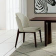 Silla acolchada con respaldo y patas de madera y detalle en ecocuero.