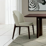 Silla acolchada con respaldo y patas de madera y detalle en ecocuero.