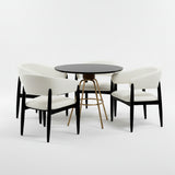 Set de mesa de comedor circular color negro con juego de cuatro sillas color blanco.