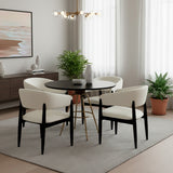 Set de mesa de comedor circular color negro con juego de cuatro sillas color blanco.