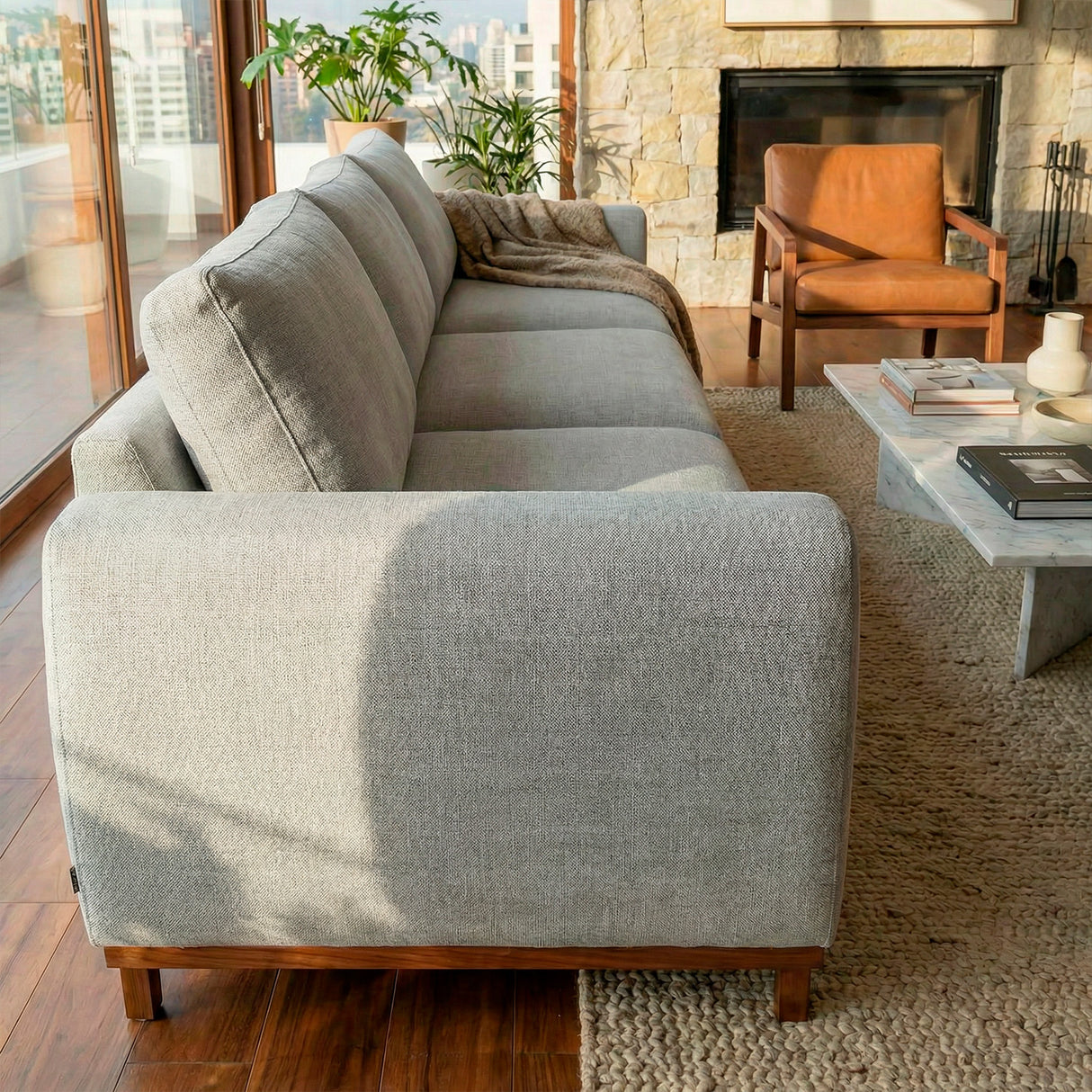 Sofá de tres cuerpos en tela lino color gris.