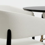 Set de mesa de comedor circular color negro con juego de cuatro sillas color blanco.