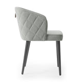 Silla con respaldo envolvente, acolchado con patrón y agarradera de metal.