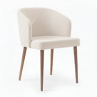 Silla con respaldo envolvente, acolchado con patrón y agarradera de metal color beige.