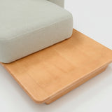 Sofá de dos cuerpos con pouf del lado derecho y mesa de madera 