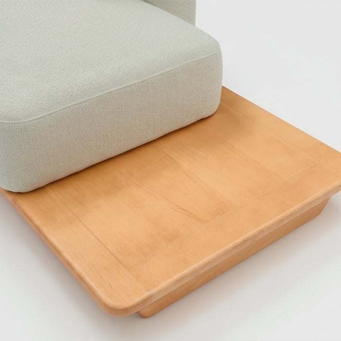 Sofá de dos cuerpos con pouf del lado derecho y mesa de madera 