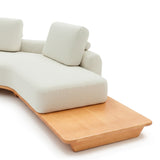 Sofá de dos cuerpos con pouf del lado derecho y mesa de madera 