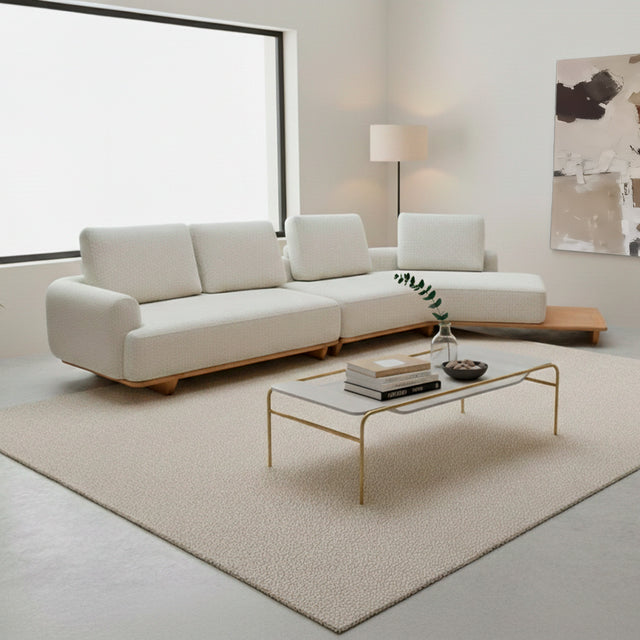 Sofá de dos cuerpos con pouf del lado derecho y mesa de madera 